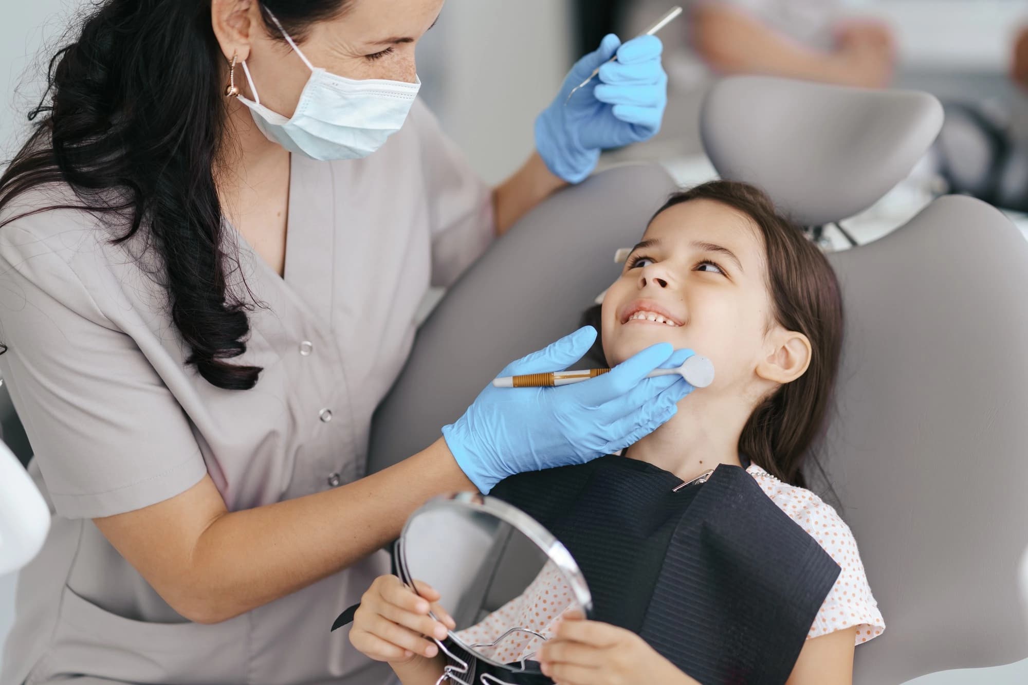 A child smiling after a gentle fluoride treatment at Dentistry at Millennium Park in Chicago