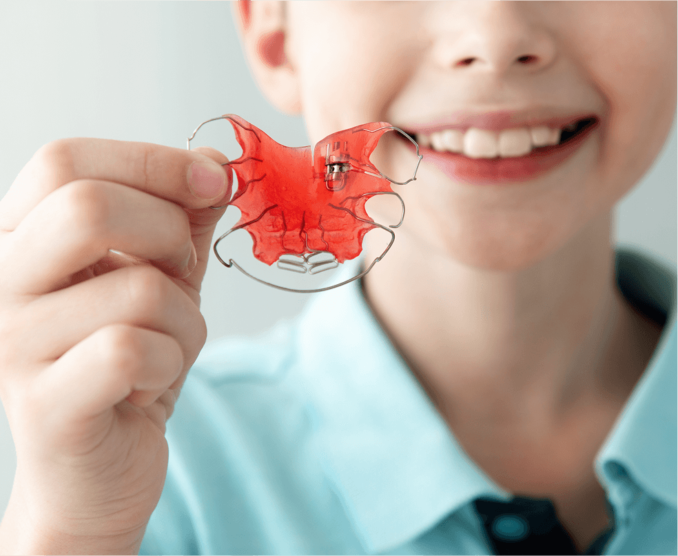 A patient holding a clear custom retainer at Dentistry at Millennium Park in Chicago