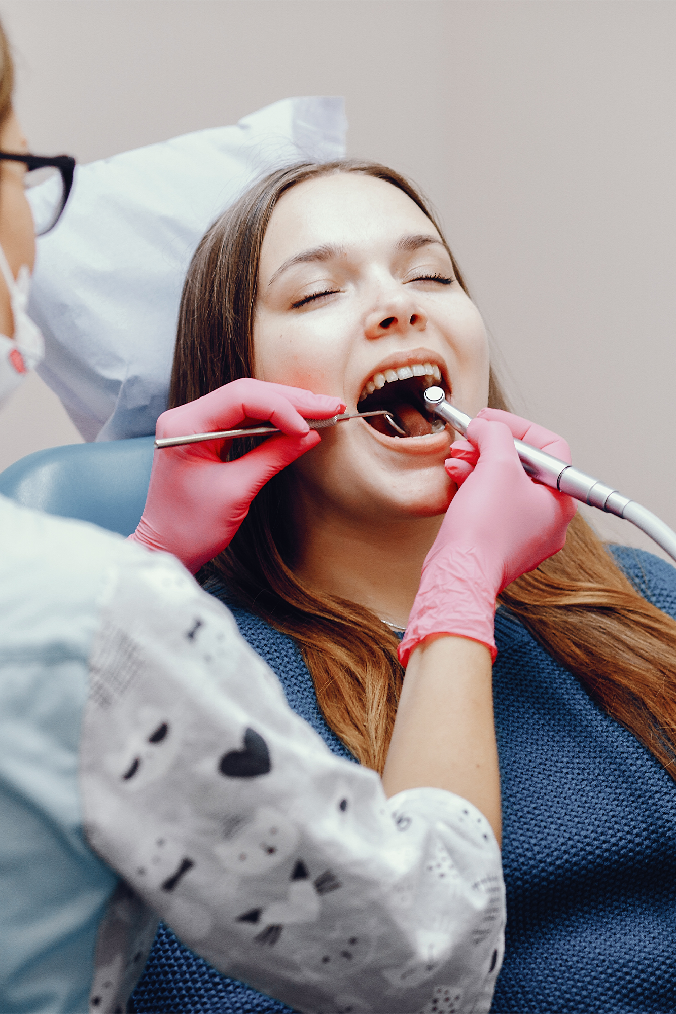 A dental hygienist cleaning a patient's teeth