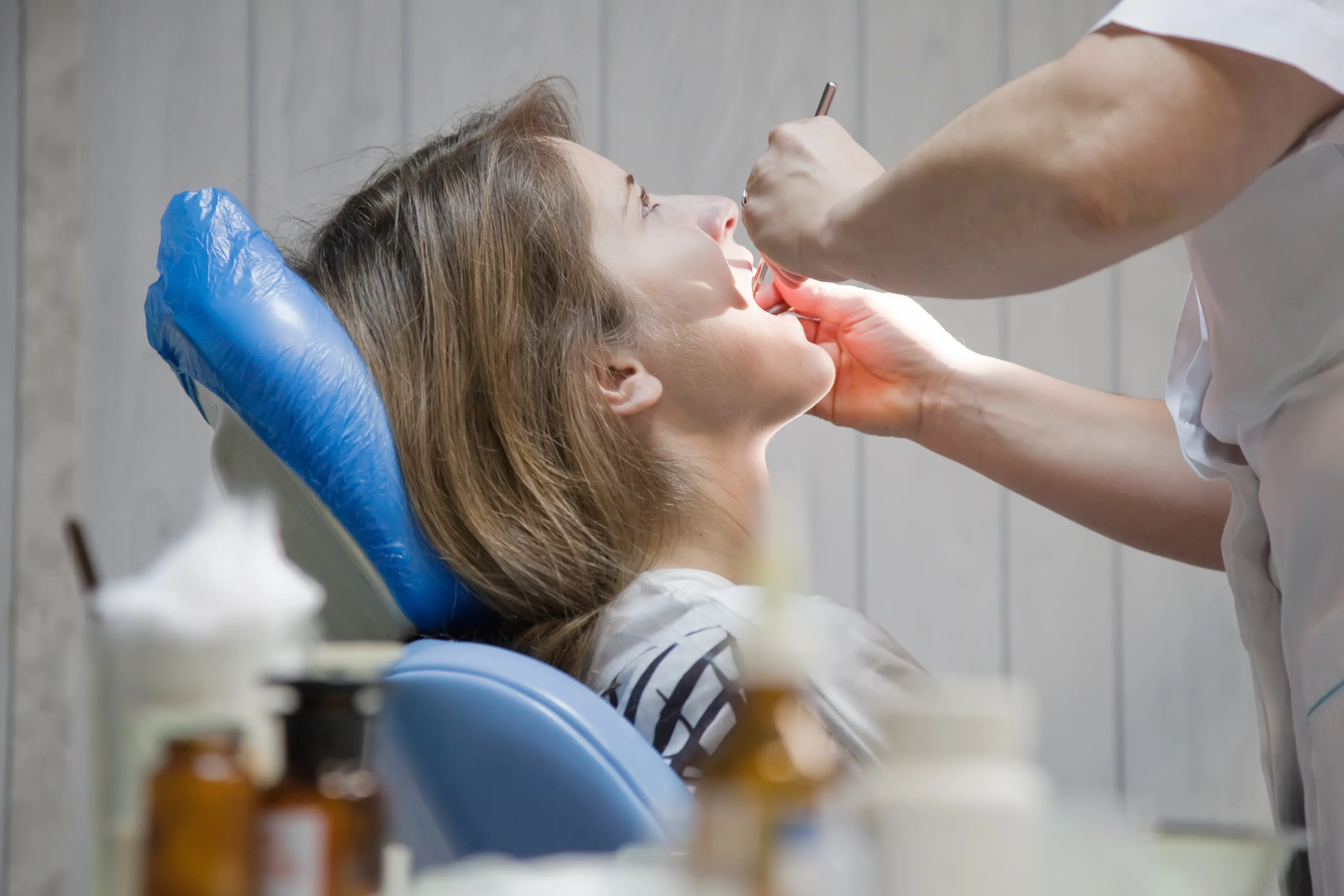 A dentist applying fluoride varnish to a patient's teeth